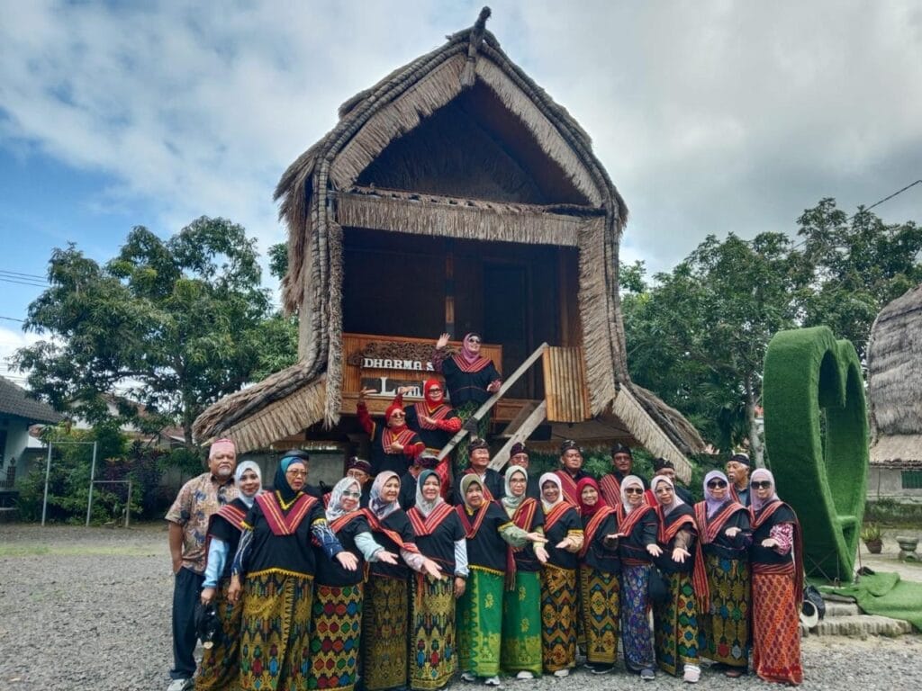 Rombongan wisatawan mengenakan pakaian adat Sasak di depan rumah Lumbung Lombok