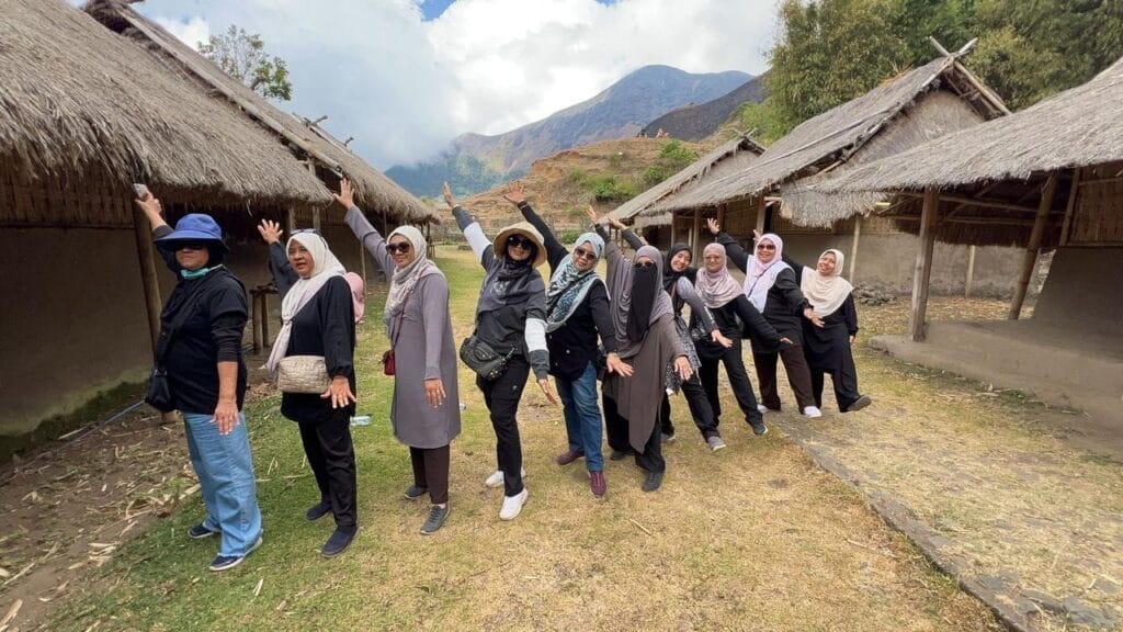 Rombongan wisata hijab traveler berfoto di Kampung Adat Sasak dengan latar belakang Gunung Rinjani.