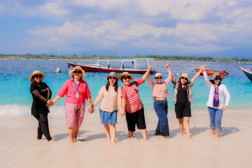 Rombongan ibu-ibu wisatawan menikmati liburan di pantai Lombok bersama Lombok Travelution