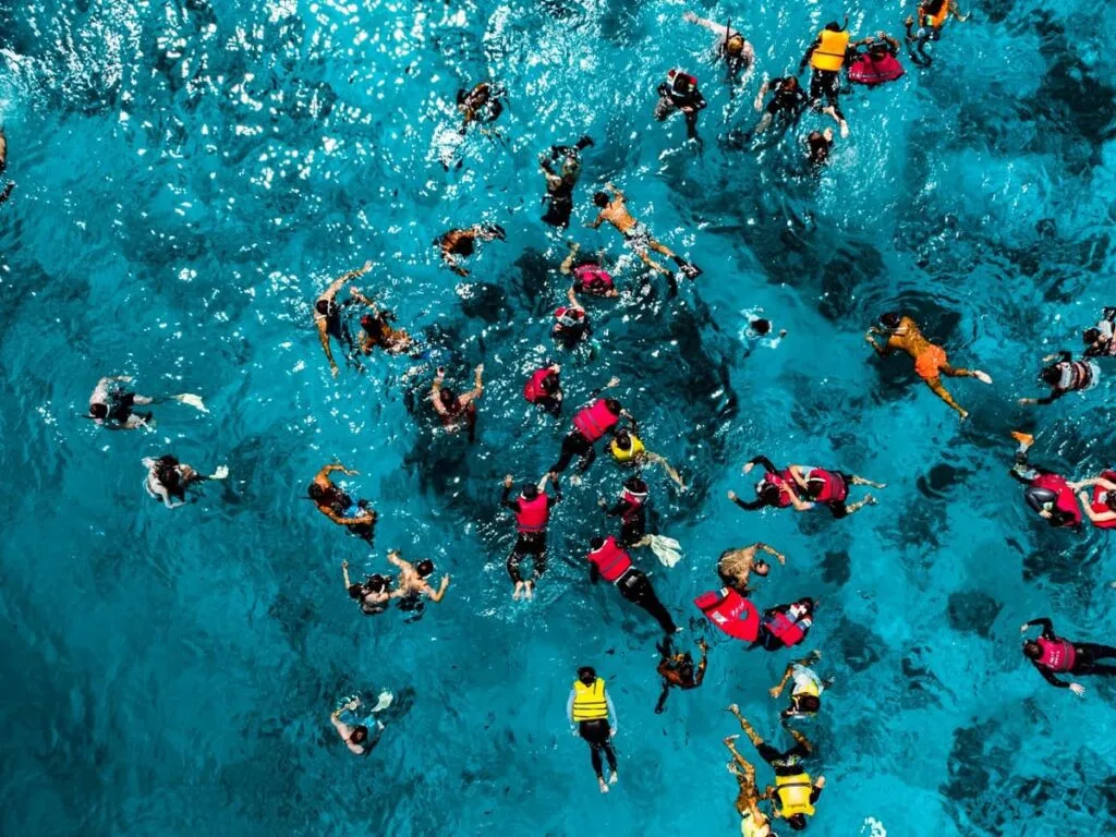 Pemandangan udara dari rombongan wisatawan yang sedang melakukan aktivitas snorkeling di perairan biru jernih Gili Trawangan, Lombok.