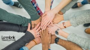 Tumpukan tangan tim yang melambangkan kebersamaan dan kekompakan dalam acara company outing di Lombok.