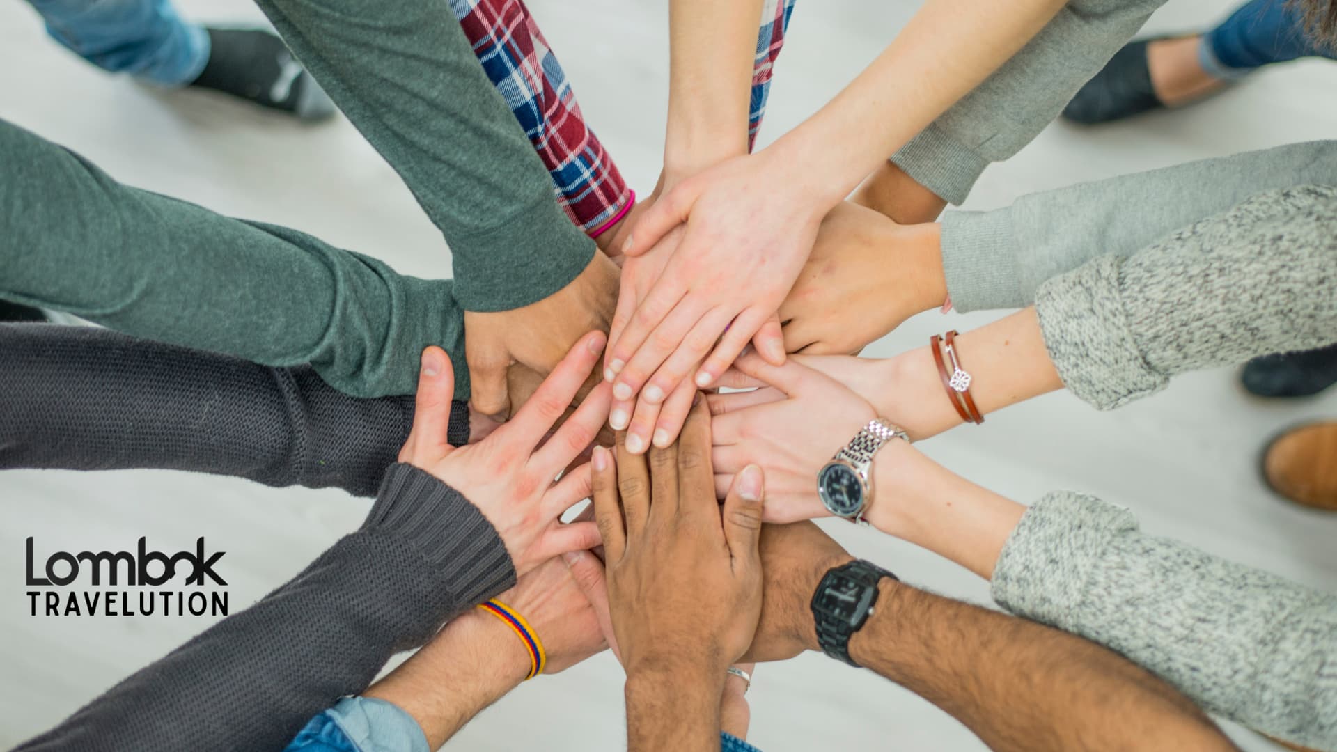 Tumpukan tangan tim yang melambangkan kebersamaan dan kekompakan dalam acara company outing di Lombok.