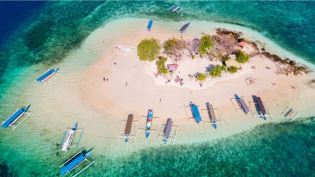 Pemandangan udara Gili Kedis Lombok dengan perahu wisata di laut biru jernih