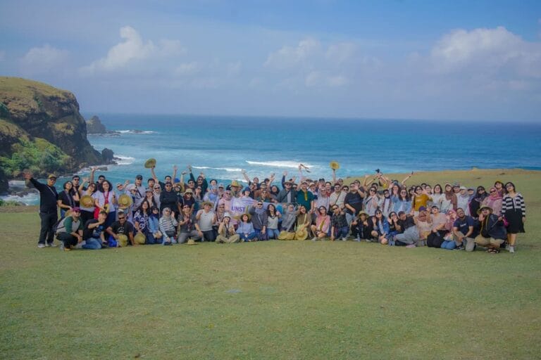 Rombongan wisatawan berfoto bersama di puncak Bukit Merese dengan latar belakang pemandangan laut Lombok Selatan yang indah.