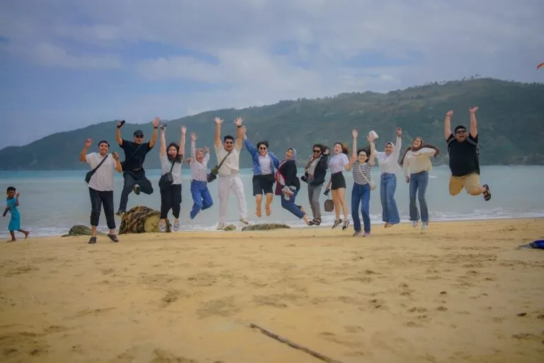 Ekspresi kegembiraan rombongan wisatawan saat melompat bersama di pantai pasir putih di Lombok.