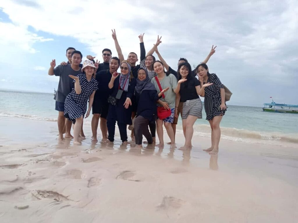 Wisatawan berfoto di Pantai Pink Lombok dalam paket tour 4 hari 3 malam bersama Lombok Travelution.
