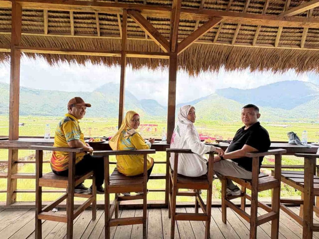Wisatawan menikmati makan siang dengan pemandangan indah Bukit Sembalun dalam paket wisata Lombok Travelution