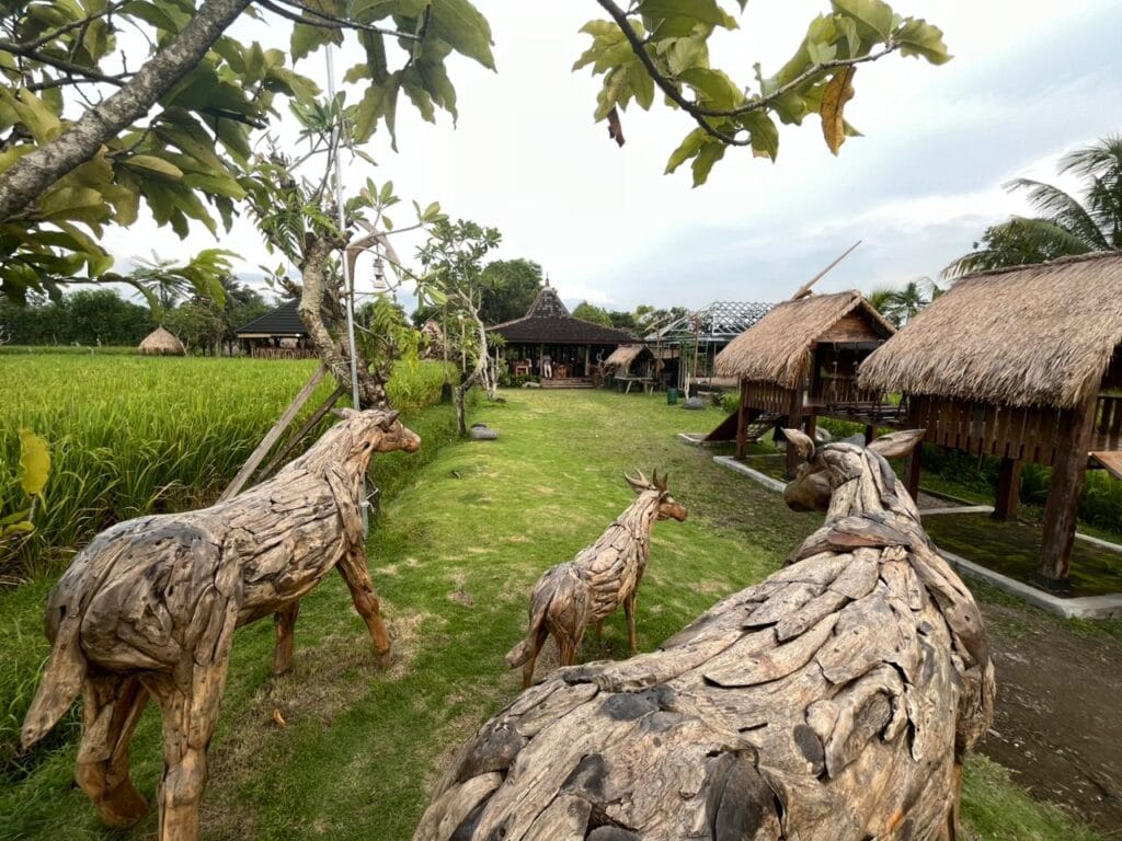 Restoran nuansa sawah di Narmada Lombok dengan dekorasi patung kuda dari akar kayu.