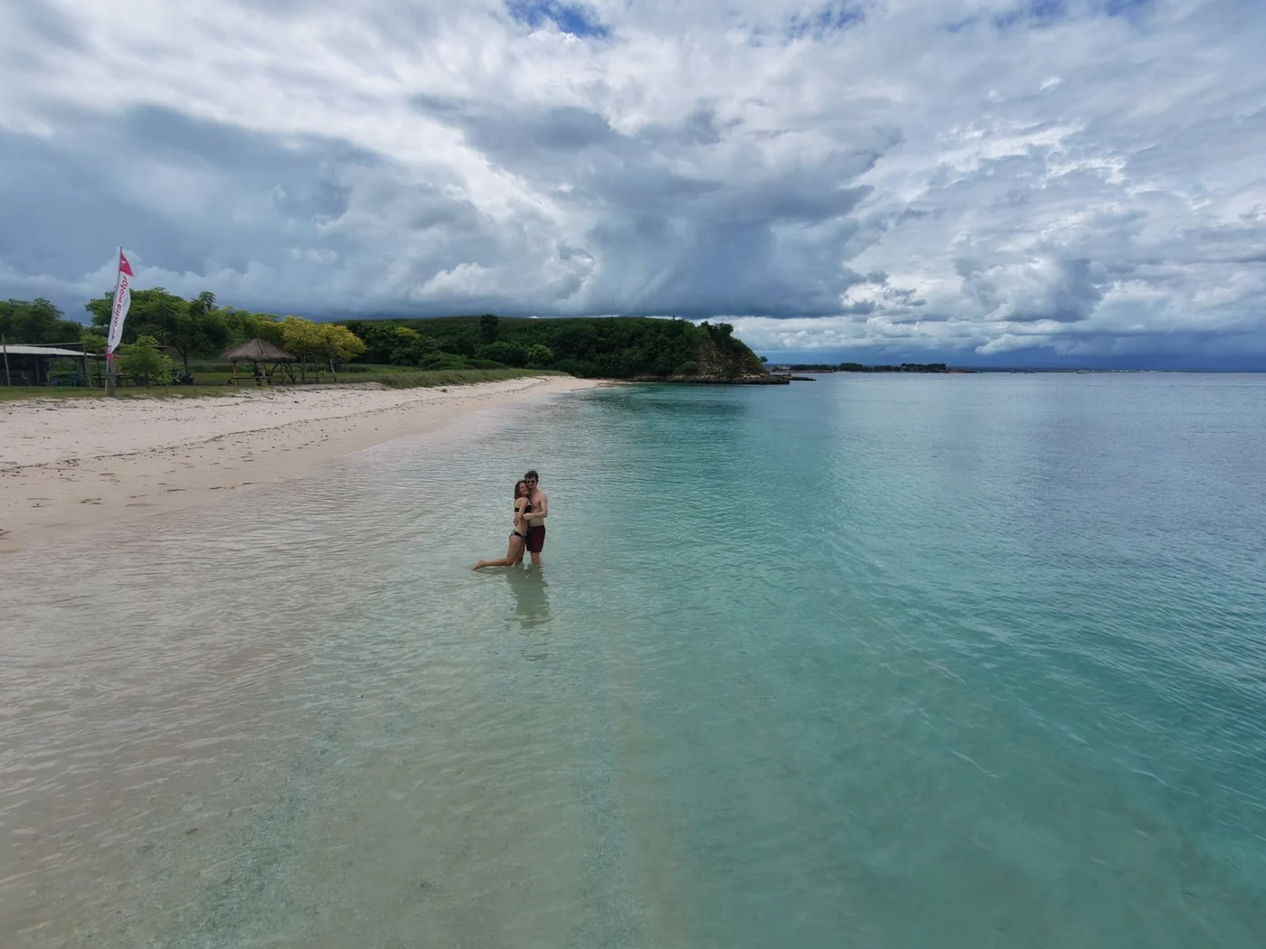 Couple standing in shallow turquoise water off a quiet Lombok island